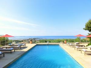 邦多勒蔚蓝高尔夫别墅酒店的一个带躺椅和遮阳伞的游泳池