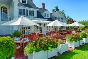 圣迈克尔斯Inn at Perry Cabin的房屋前设有带桌子和遮阳伞的庭院。