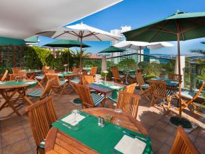 伊斯坦布尔格米尔帕莱酒店 - 特殊类的餐厅设有木桌、椅子和遮阳伞