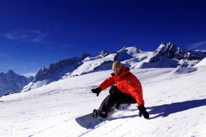 菲施帕克酒店的骑着滑雪板沿着雪覆盖的山下骑着雪地的人
