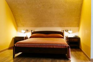 马泰拉德尔卡萨尔诺沃住宅酒店的一间卧室配有一张床、两个床头柜和两盏灯。