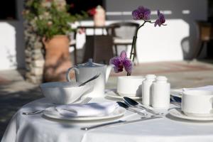 波尔塔里亚德斯波狄科酒店的一张桌子,上面有白色的桌布,上面有银器和紫色的花