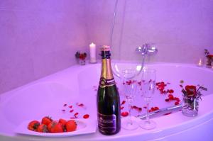 穆斯克龙Les Chambres d'Elza的浴缸里备有一瓶香槟和一盘草莓