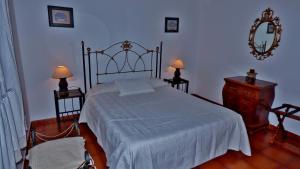弗龙特拉Casa Guinea的一间卧室配有一张床、两盏灯和一面镜子
