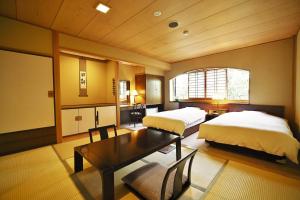 日田市风早酒店的一间卧室配有两张床和一张桌子