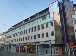 格拉茨City Apartmentstudio mit Tiefgarage free parking的一条城市街道上的白色大建筑