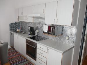 格拉茨City Apartmentstudio mit Tiefgarage free parking的厨房配有白色橱柜和台面