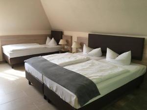 兰茨贝格兰茨贝格酒店的一间卧室配有两张带白色床单和枕头的床。