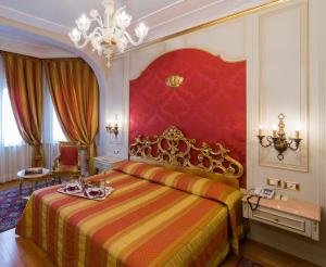 斯特雷萨蕾佳娜皇宫酒店的一间卧室配有一张特大号床和吊灯。