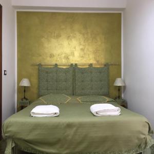 夏卡Casa Terme的绿色的床,上面有两条毛巾