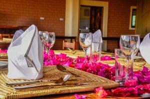卡拉图佩贝尼罗提亚旅馆的一张桌子,上面放着酒杯和粉红色的鲜花