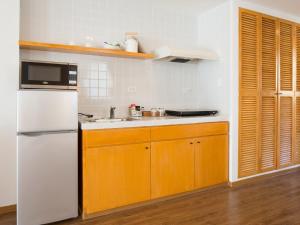 科罗尔科罗尔中心花园皇宫酒店的厨房配有白色冰箱和木制橱柜。