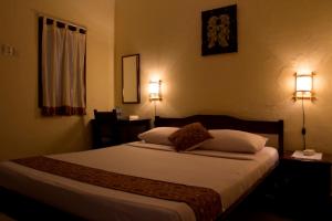 日惹安德烈住宿加早餐旅馆的卧室配有一张带两盏灯的墙壁床。