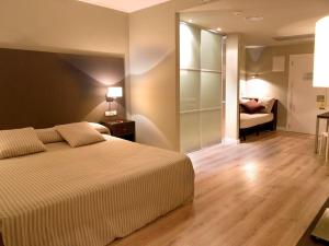 拉莫利纳HG拉莫利纳酒店的一间卧室配有一张床,另一间卧室配有沙发。