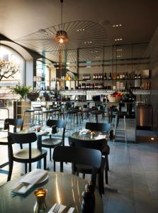 斯德哥尔摩Nobis Hotel Stockholm, a Member of Design Hotels™的一间带桌椅的餐厅和一间酒吧