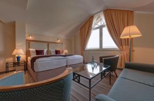 奥斯赛拜-屈隆斯博恩海蓝玉酒店的酒店客房配有一张床铺和一张桌子。