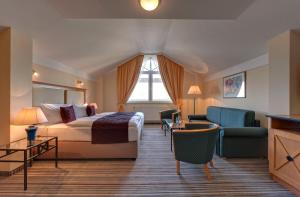 奥斯赛拜-屈隆斯博恩海蓝玉酒店的酒店客房配有床、沙发和桌子。