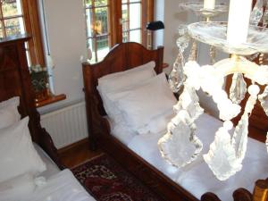 伊诺弗罗茨瓦夫威拉维多利亚旅馆的一间卧室配有两张床和吊灯。