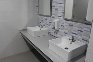 波尔托马林Albergue Folgueira的浴室设有2个白色水槽和镜子