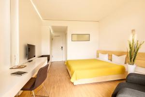 多森海姆米多里 - 绿色宾馆的酒店客房配有黄色的床和沙发
