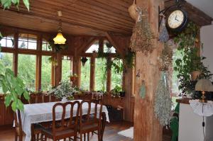 斯克拉斯卡波伦巴Villa Nostalgia的一间设有桌子和墙上时钟的餐厅