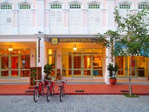 马六甲卡皮坦会馆精品酒店的停放在大楼前的两辆自行车