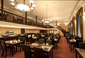 卡罗维发利卡罗维发利千禧Spa酒店的用餐室配有桌椅和吊灯。