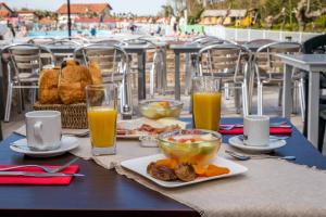 圣让-德吕兹Hôtel Prestige Odalys Erromardie的餐桌,带食物和橙汁杯