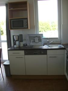 格罗森布罗德Apartment Seestern的厨房配有水槽和微波炉