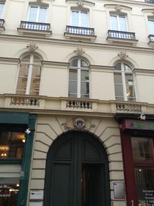 巴黎艾塔吉歌剧1号酒店的一座白色的大建筑,设有黑色的门