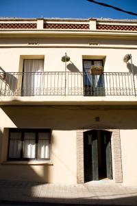 莱斯卡拉L'Escala - Pintor Massanet的带阳台和窗户的白色建筑