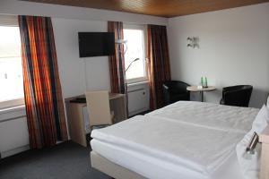 楚赫维尔满婷福酒店的一间酒店客房,配有一张白色的床和一张书桌
