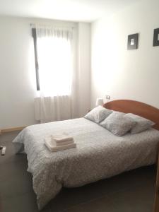 阿尔巴拉辛Apartamentos Los Mayos de Albarracín的白色卧室设有一张带窗户的床