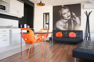 蒙得维的亚Rentline Apartamentos - Sunline的厨房配有桌椅和一幅女子画