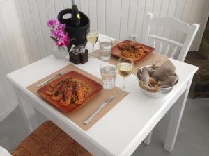 伊亚莱奥卡斯缇别墅酒店的一张带两盘食物和酒杯的白桌