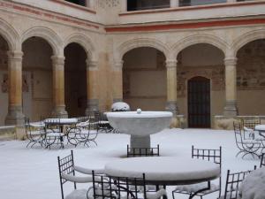 塞哥维亚圣安托尼奥皇家酒店的雪覆盖着桌子和喷泉的庭院