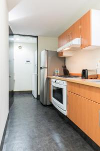 墨西哥城Boutique Apartment Puerta Alameda-801的厨房配有木制橱柜和不锈钢冰箱。