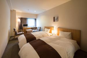 松山查哈茹酒店的酒店客房配有两张床和一张书桌