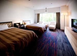 松山查哈茹酒店的酒店客房设有两张床和一台平面电视。