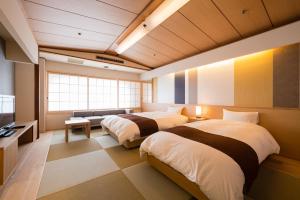 松山查哈茹酒店的一间设有两张床和电视的房间