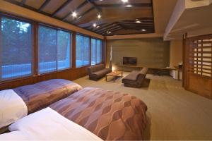 草津草津斯凯兰酒店的一间卧室设有两张床、一台电视和窗户。
