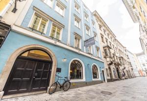 林茨戈特弗里德食饮寝酒店的停在蓝色建筑前面的自行车
