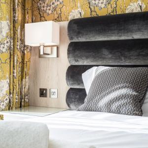 诺丁汉The Residence Hotel at The Nottinghamshire Golf & Country Club的一间卧室配有一张带黑色床头板和灯的床。