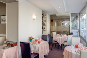 萨尔特河畔博蒙巴克之家酒店的餐厅设有2张桌子和椅子,配有粉红色的桌布