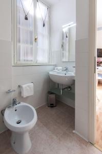 格拉多埃里卡别墅酒店的白色的浴室设有水槽和卫生间。