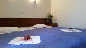 科林斯雅典卫城酒店的两张床,上面有毛巾和食物