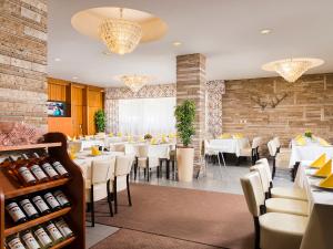 尼赖吉哈佐Ózoon Hotel的一间设有白色桌椅的用餐室