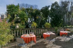 蒙彼利埃贝斯特韦斯特奎尔姆酒店的花园内两张桌子、红色桌布和椅子