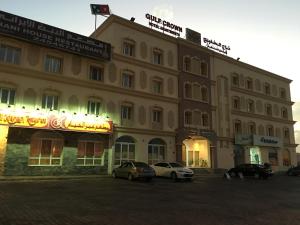 锡卜海湾皇冠酒店公寓的一座大型建筑,前面有汽车停放