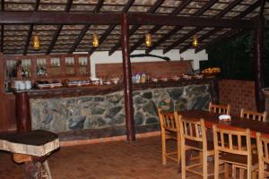 博尼图风车酒店的餐厅设有酒吧,配有木桌和椅子